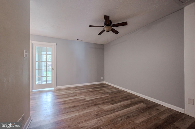 empty room with baseboards, ceiling fan, visible vents, and wood finished floors