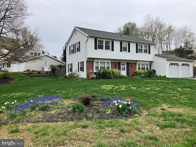 colonial home with an attached garage, brick siding, and a front yard