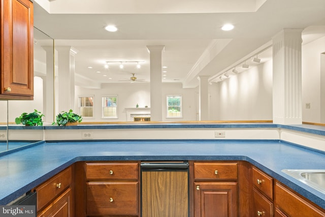 kitchen featuring ceiling fan, decorative columns, rail lighting, brown cabinets, and dark countertops