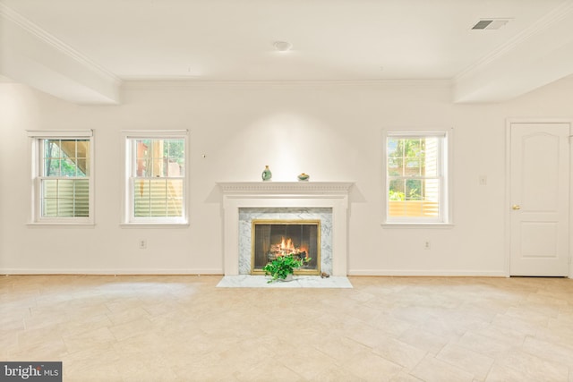 unfurnished living room featuring plenty of natural light, visible vents, and ornamental molding