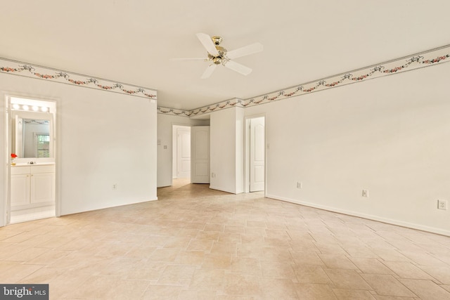 interior space featuring baseboards, ensuite bath, and ceiling fan