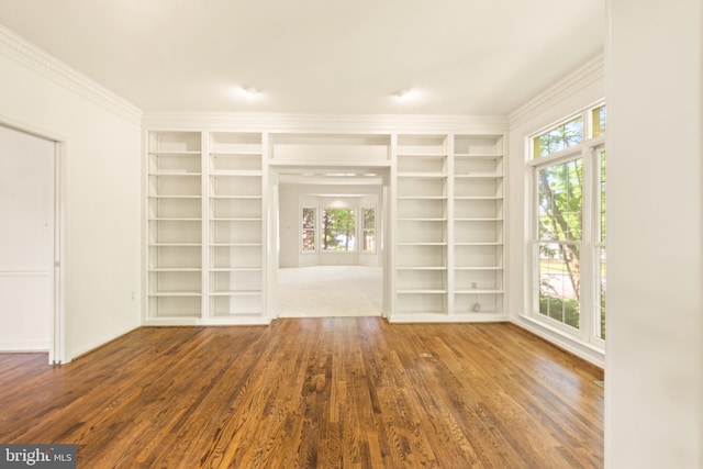 interior space with baseboards, ornamental molding, wood finished floors, and built in shelves