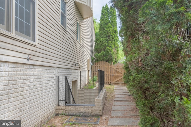 view of side of home with a gate and fence