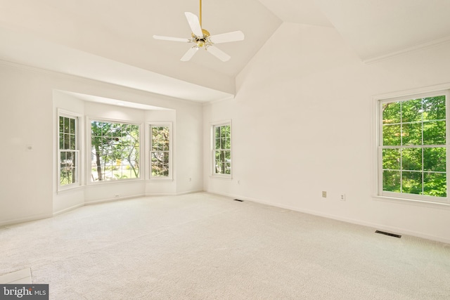 carpeted empty room with baseboards, a ceiling fan, high vaulted ceiling, and visible vents