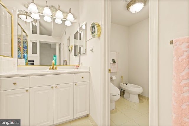 bathroom with tile patterned flooring, a bidet, toilet, and vanity