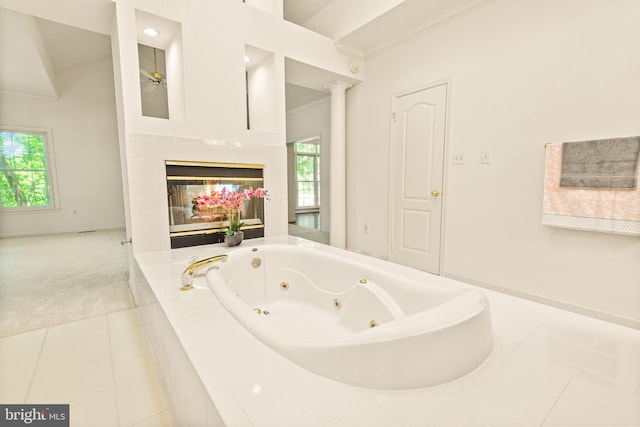 full bathroom featuring a jetted tub, baseboards, tile patterned floors, and a healthy amount of sunlight