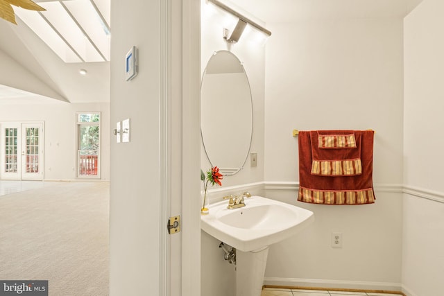 bathroom featuring baseboards and lofted ceiling with skylight