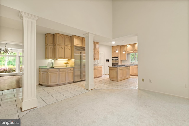 interior space with a towering ceiling, baseboards, light carpet, ornate columns, and light tile patterned flooring