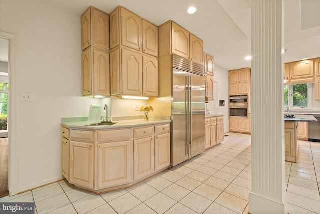 kitchen featuring light brown cabinetry, light tile patterned flooring, recessed lighting, a sink, and appliances with stainless steel finishes