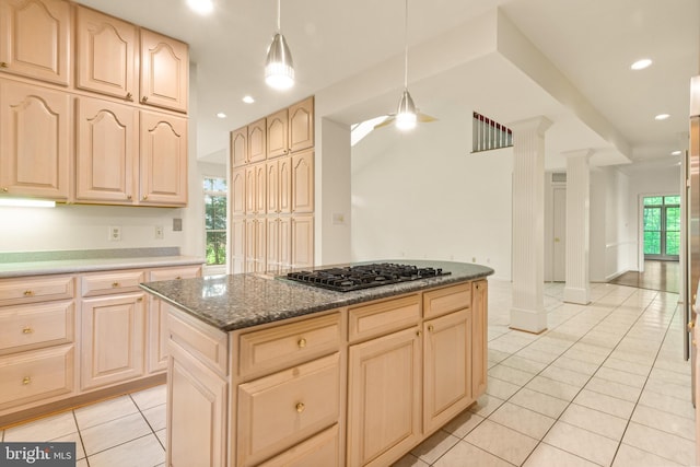 kitchen with a kitchen island, light brown cabinetry, hanging light fixtures, stainless steel gas cooktop, and light tile patterned flooring