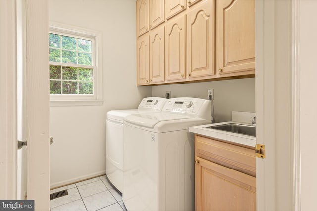 clothes washing area with a sink, cabinet space, independent washer and dryer, light tile patterned flooring, and baseboards