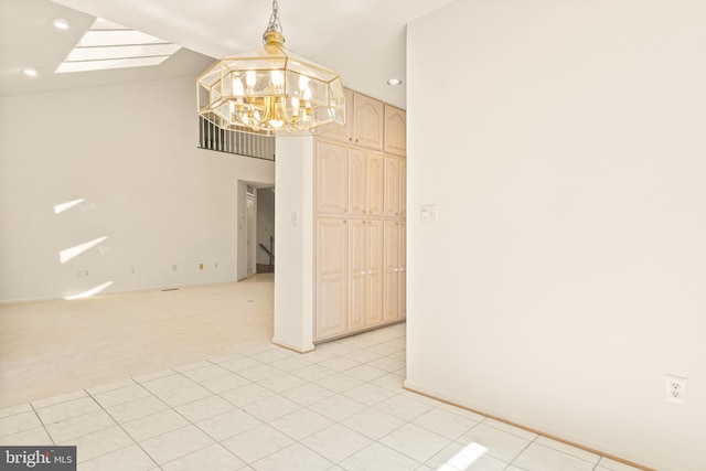 empty room featuring an inviting chandelier, lofted ceiling, baseboards, and recessed lighting