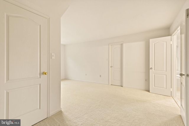 carpeted spare room featuring baseboards