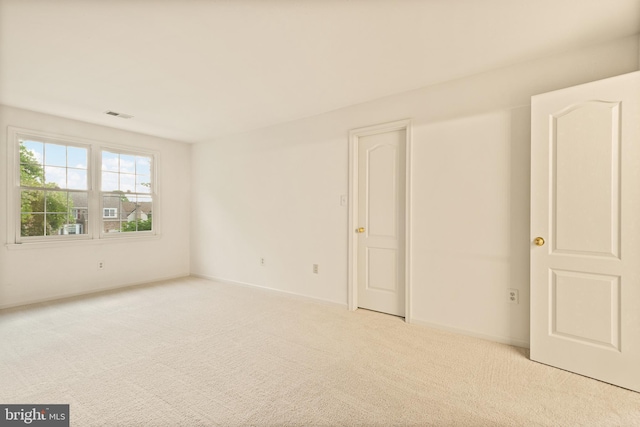 unfurnished room with carpet flooring, visible vents, and baseboards
