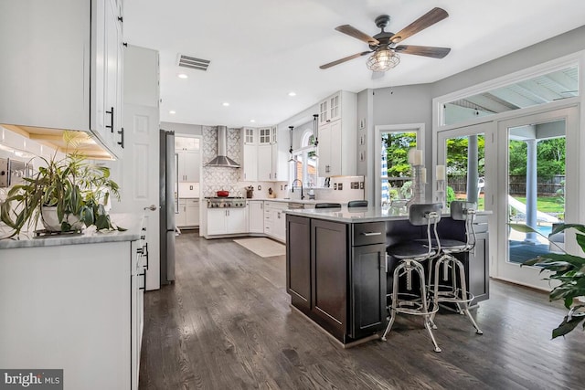 2840 Dunleigh Dr, Dunkirk, MD 20754 - kitchen featuring decorative backsplash, a ceiling fan, appliances with stainless steel finishes, white cabinets, and wall chimney exhaust hood