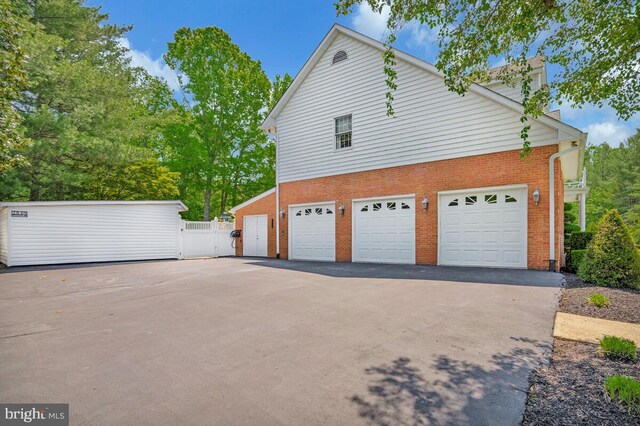 2840 Dunleigh Dr, Dunkirk, MD 20754 - view of property exterior with brick siding, aphalt driveway, fence, and a chimney