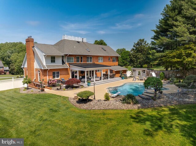 2840 Dunleigh Dr, Dunkirk, MD 20754 - rear view of house featuring a fenced backyard, a yard, a chimney, a fenced in pool, and an outbuilding