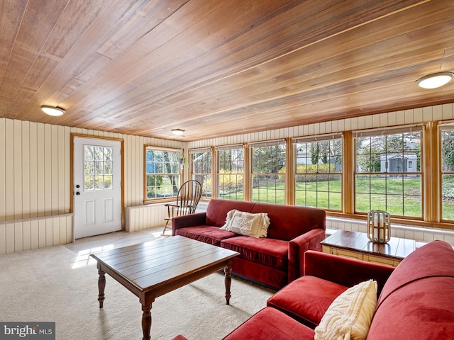 carpeted living room with wood walls and wood ceiling