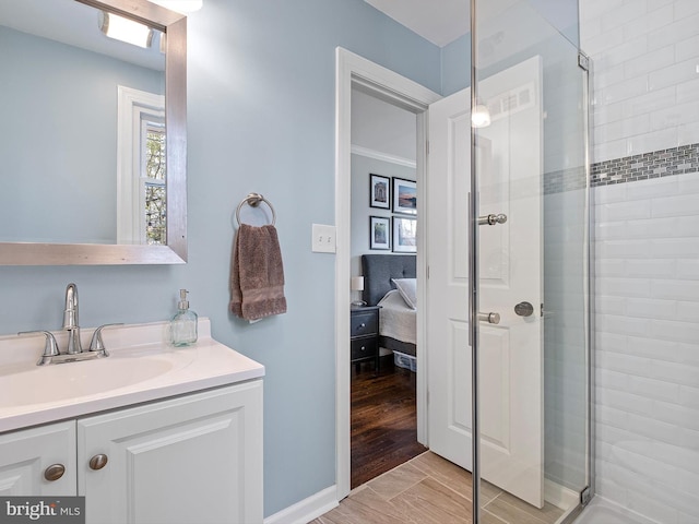ensuite bathroom with ensuite bathroom, a shower stall, vanity, and a healthy amount of sunlight