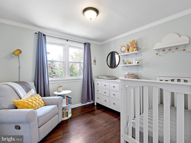 bedroom featuring crown molding, baseboards, dark wood finished floors, and a crib