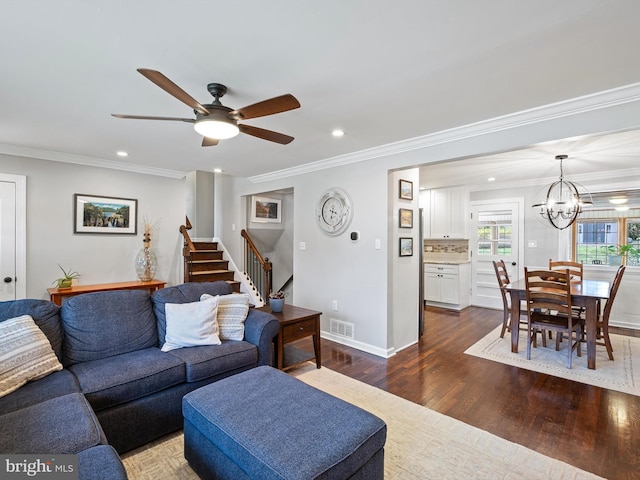 living room featuring crown molding, recessed lighting, ceiling fan with notable chandelier, and dark wood-type flooring