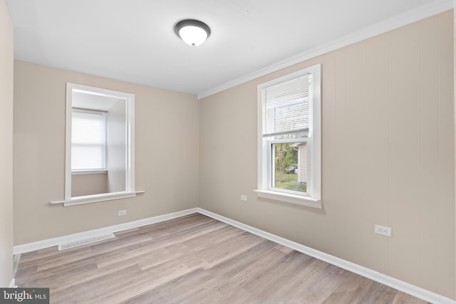 unfurnished room featuring baseboards, visible vents, plenty of natural light, and light wood-type flooring