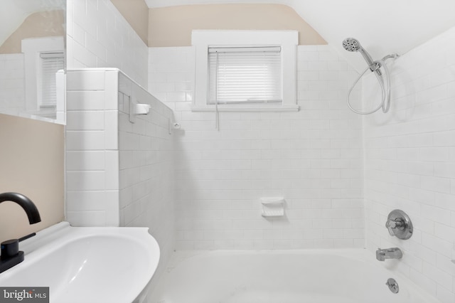 bathroom featuring shower / tub combination, a sink, and lofted ceiling