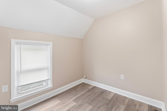additional living space with baseboards, vaulted ceiling, and wood finished floors