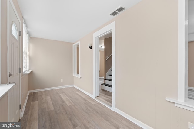 entryway featuring baseboards, visible vents, stairway, and light wood-type flooring