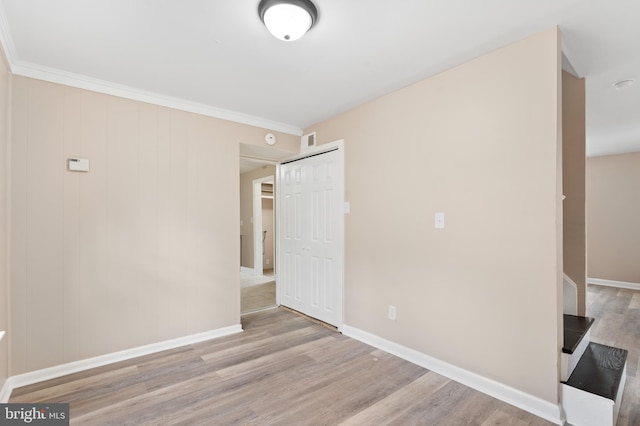 unfurnished bedroom with baseboards, wood finished floors, and visible vents