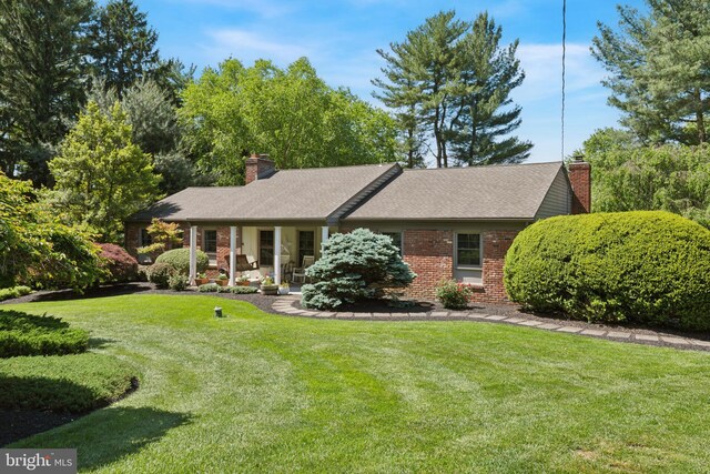 432 Spring Valley Rd, Media, PA 19063 - view of front facade with a chimney, brick siding, a front lawn, and a porch