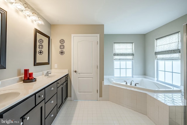 bathroom with double vanity, tile patterned floors, a sink, and a bath