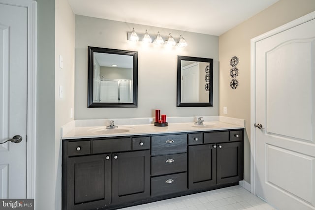full bath featuring double vanity, a sink, and tile patterned flooring