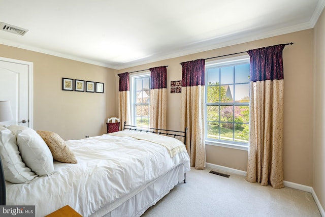 carpeted bedroom featuring crown molding, multiple windows, and visible vents