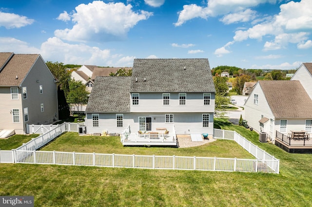 rear view of house with a fenced backyard, a wooden deck, a shingled roof, and a yard