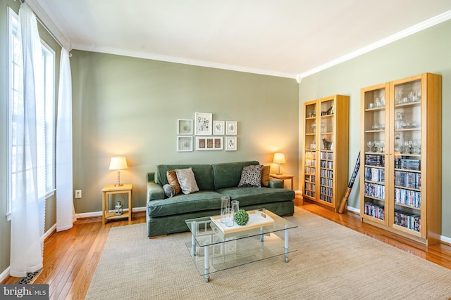 living room with crown molding, baseboards, and wood finished floors