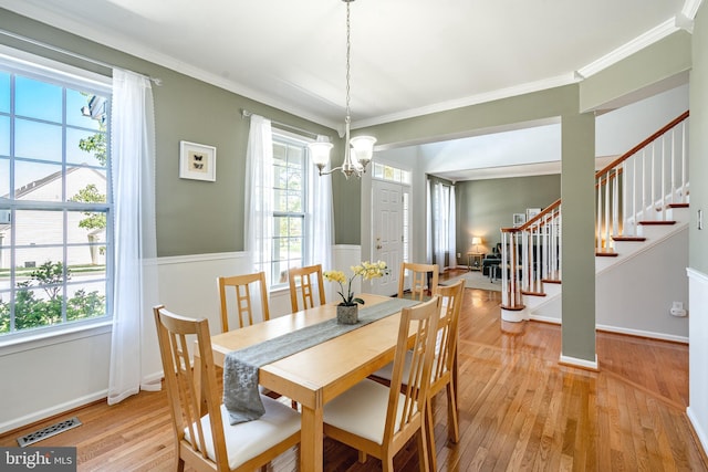 dining area with a healthy amount of sunlight, stairs, a chandelier, and visible vents