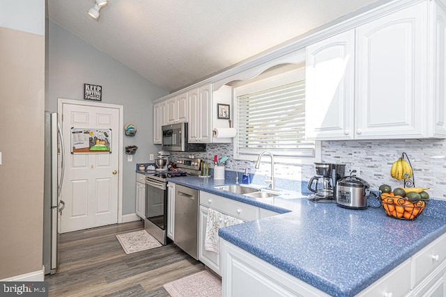 8 Candytuft Ln, Ocean Pines, MD 21811 - kitchen featuring a sink, stainless steel appliances, vaulted ceiling, backsplash, and white cabinets
