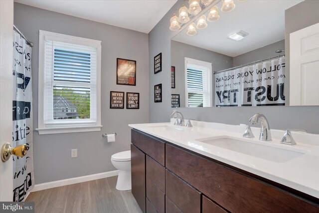 full bathroom with wood finished floors, baseboards, toilet, double vanity, and a shower with shower curtain