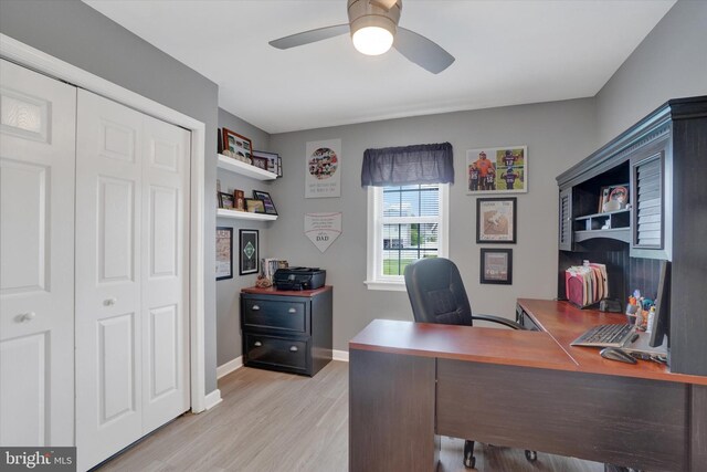 office space featuring a ceiling fan, light wood-style flooring, and baseboards