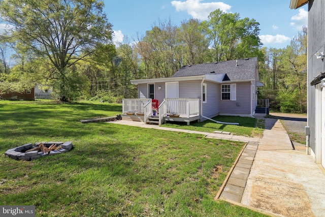5160 Miller Hill Rd, La Plata, MD 20646 - back of house featuring a fire pit, a lawn, a wooden deck, and roof with shingles