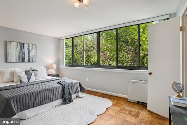bedroom featuring baseboards and multiple windows