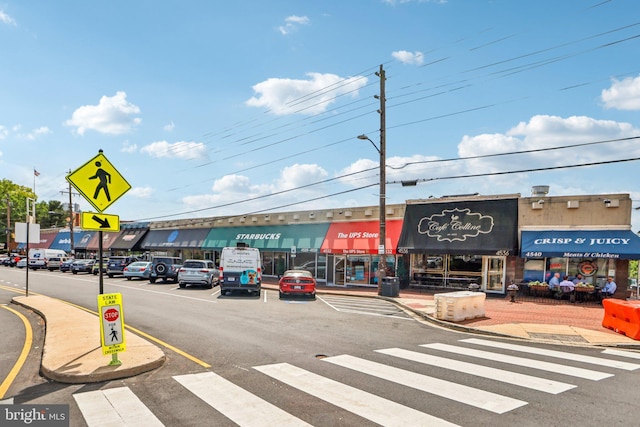 view of road featuring street lighting, traffic signs, and curbs