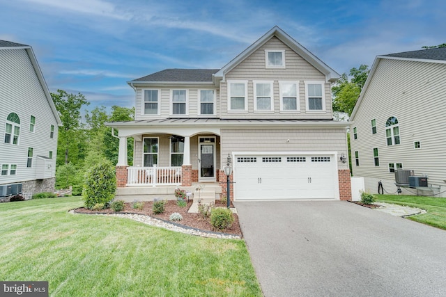 view of front of home featuring covered porch, a garage, a front yard, driveway, and a standing seam roof