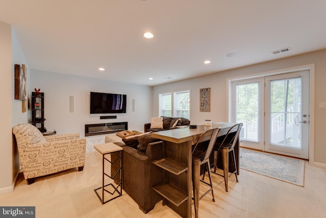 living area featuring light colored carpet, baseboards, visible vents, and recessed lighting