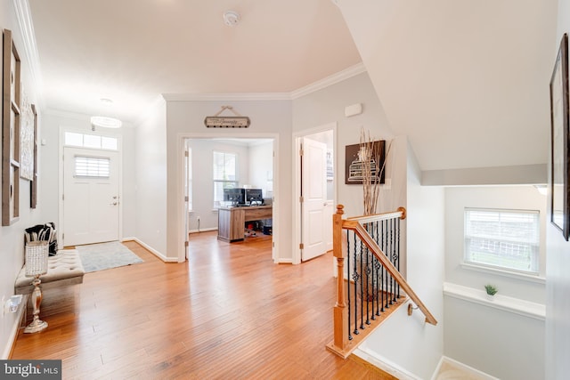 entryway featuring light wood finished floors, baseboards, and ornamental molding