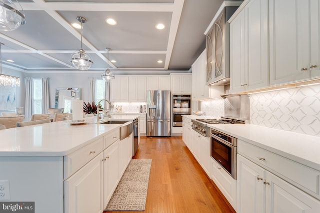 kitchen featuring white cabinets, stainless steel appliances, and light wood-style flooring