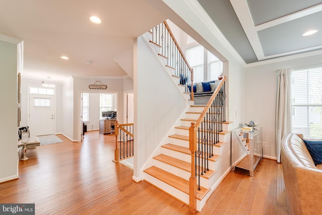 staircase with crown molding, wood finished floors, baseboards, and recessed lighting