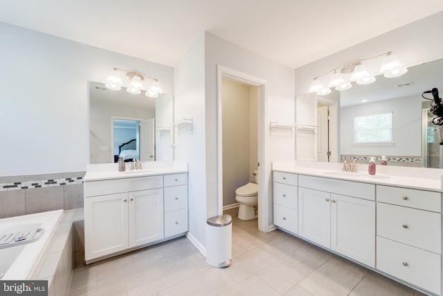 full bathroom featuring a sink, tile patterned flooring, toilet, and two vanities