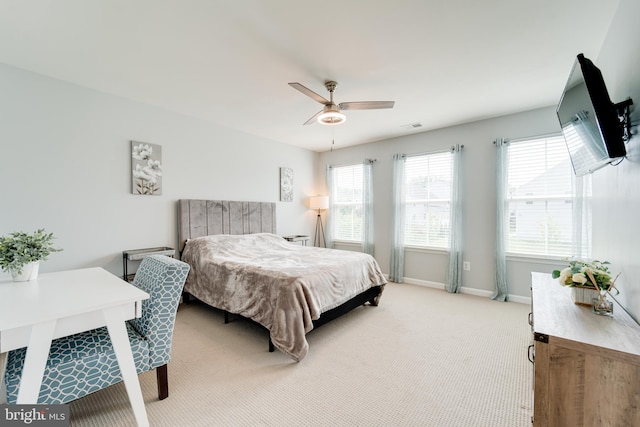bedroom featuring baseboards, visible vents, a ceiling fan, and light colored carpet